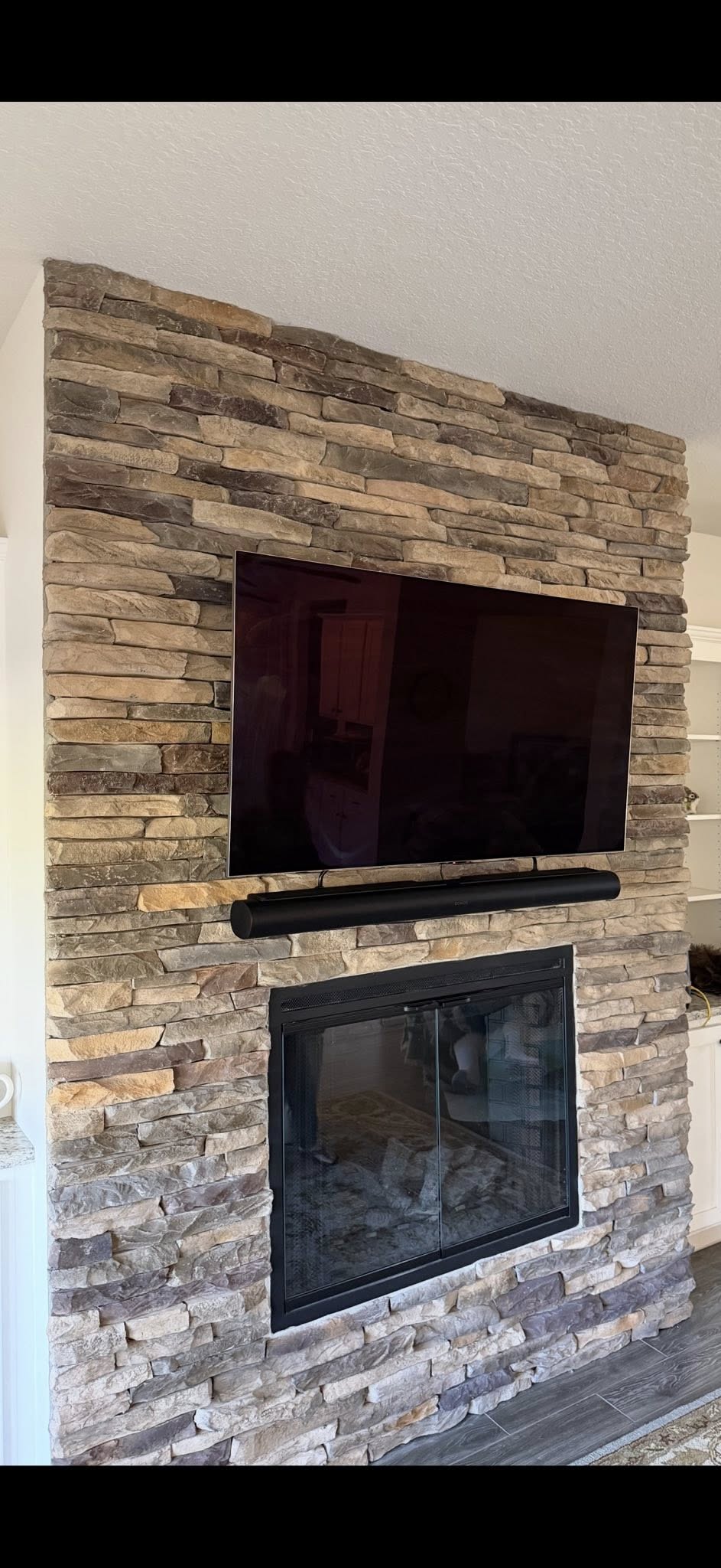 TV mounted on stone fireplace wall